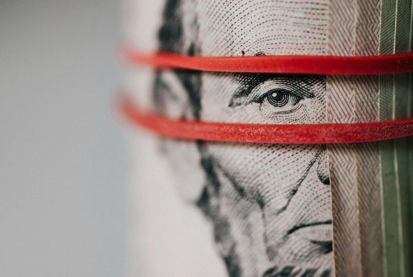 Close-up of rolled dollar bills representing bundled loans and debt ownership through securitization
