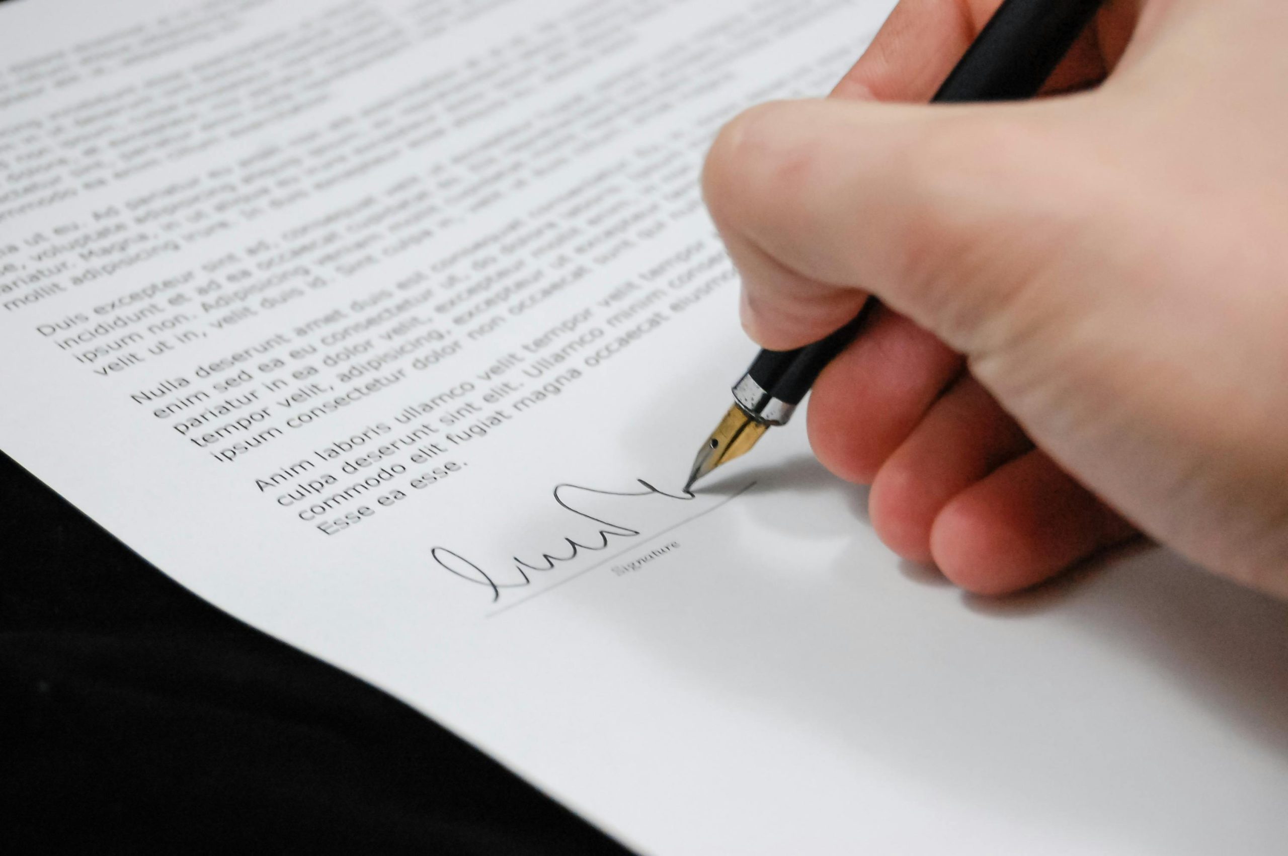 Close-up of a signature on a legal document related to debt ownership and financial agreements