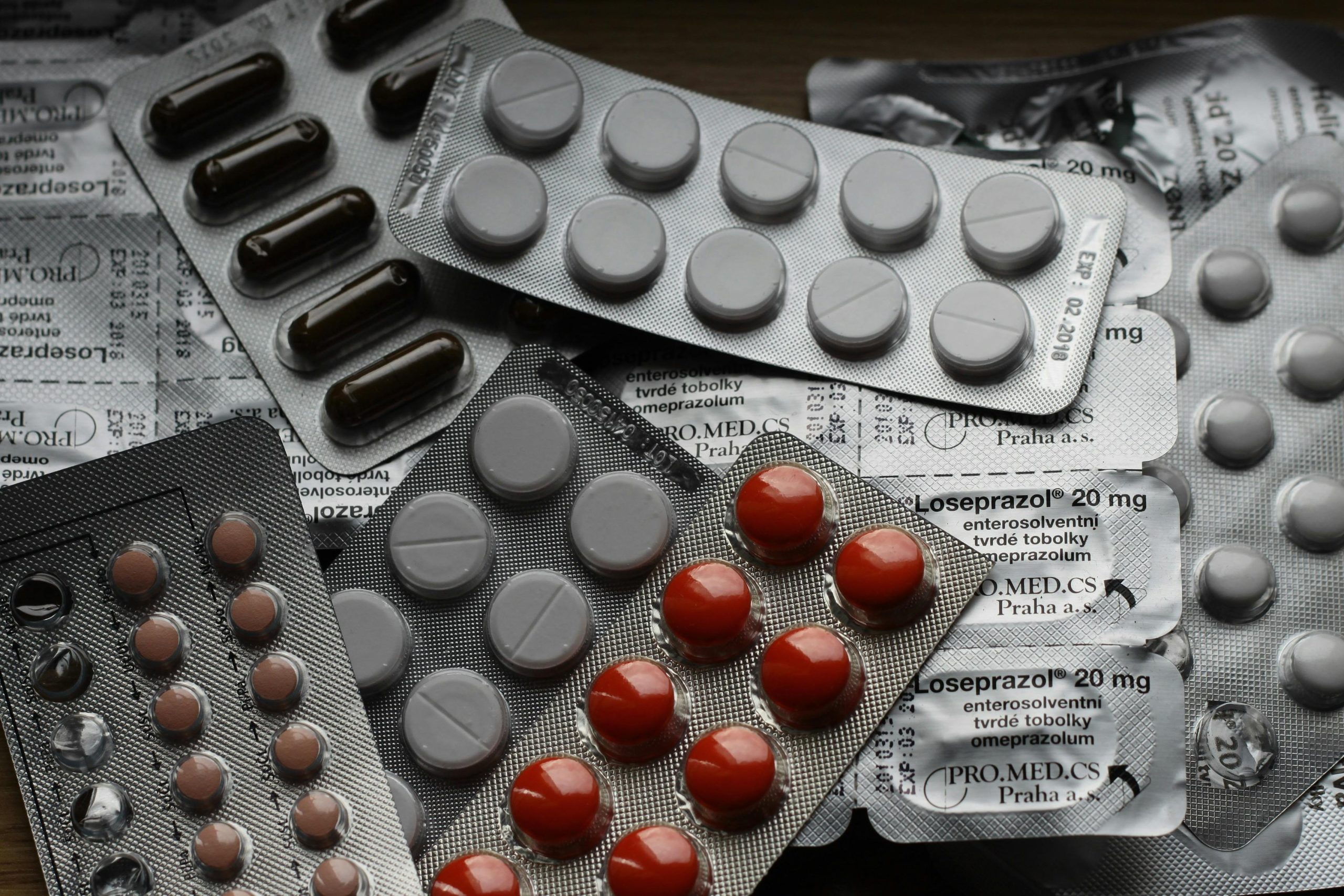 Prescription pills in blister packs representing medical debt in Canada from uncovered drug costs.